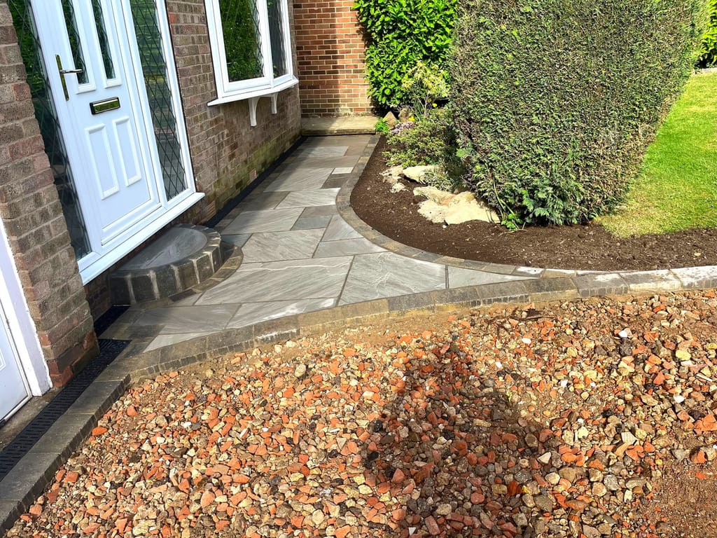 Sandstone front path with charcoal edging complete, the beds beside it still to be finished