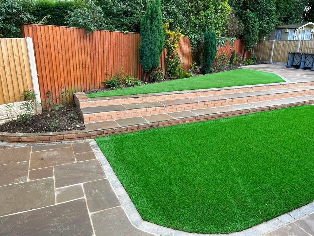 Two artificial lawns on split levels divided by a brick faced sandstone step