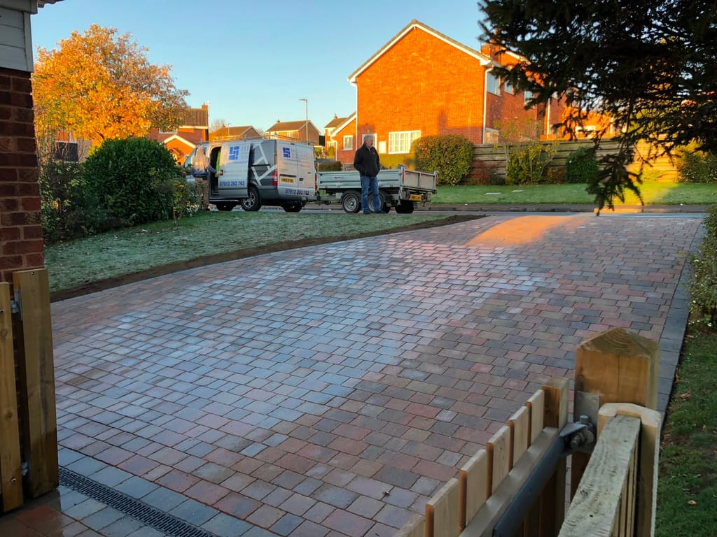 Block paved driveway on a frosty morning beside a timber post and rail fence